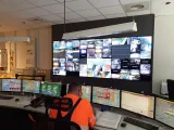 un agent devant 7 ordinateur allign&eacute;s dans le centre de contr&ocirc;le de l'UVETD devant une tr&egrave;s grande t&eacute;l&eacute;vision affichant les diff&eacute;rentes vues de cam&eacute;ra de l'usine d'incin&eacute;ration